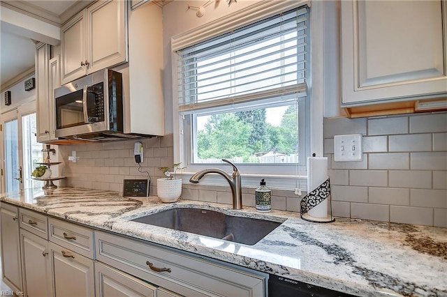 1052 Sunnyside Dr, Virginia Beach, VA 23464 - kitchen featuring stainless steel microwave, a sink, backsplash, and light stone counters