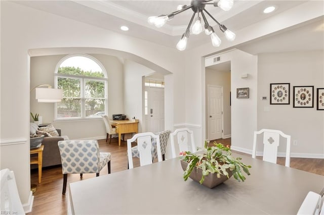 433 Fall Ridge Ln, Chesapeake, VA 23322 - dining area with a chandelier, arched walkways, wood finished floors, a tray ceiling, and recessed lighting