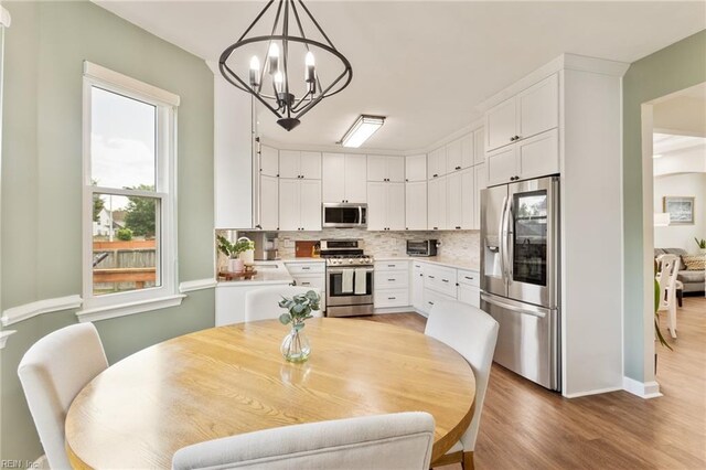 433 Fall Ridge Ln, Chesapeake, VA 23322 - dining area featuring light wood-style floors, a chandelier, and baseboards