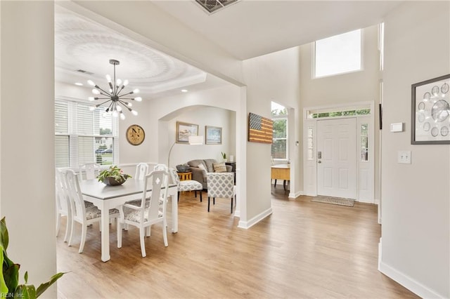 433 Fall Ridge Ln, Chesapeake, VA 23322 - entryway featuring light wood-style flooring, a chandelier, baseboards, a tray ceiling, and arched walkways