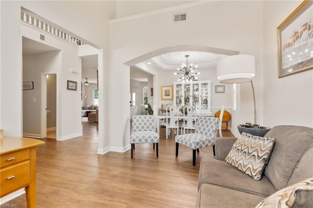 433 Fall Ridge Ln, Chesapeake, VA 23322 - living area with light wood-type flooring, arched walkways, a chandelier, baseboards, and a towering ceiling