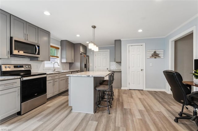 203 Old Seaford Rd, Seaford, VA 23696 - kitchen with stainless steel appliances, gray cabinets, a breakfast bar area, backsplash, and ornamental molding