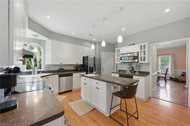 3234 Bentham Ln, Chesapeake, VA 23321 - kitchen featuring stainless steel appliances, dark countertops, a kitchen bar, an island with sink, and backsplash