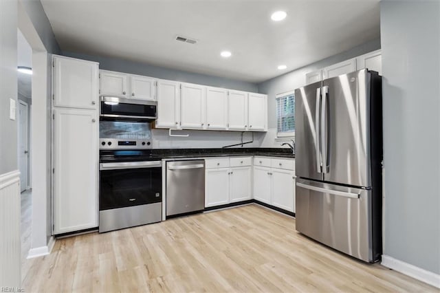 500 Mango Dr, Virginia Beach, VA 23452 - kitchen featuring appliances with stainless steel finishes, light wood-style flooring, white cabinets, dark countertops, and recessed lighting