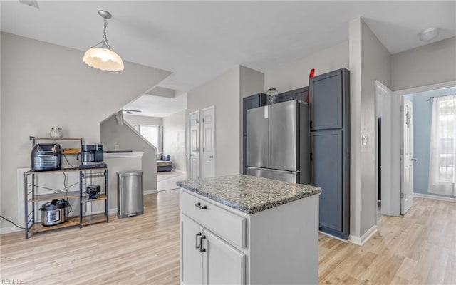 6329 Pelican Cres S, Suffolk, VA 23435 - kitchen with freestanding refrigerator, light wood finished floors, light stone counters, and baseboards