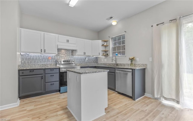6329 Pelican Cres S, Suffolk, VA 23435 - kitchen with appliances with stainless steel finishes, exhaust hood, open shelves, gray cabinetry, and backsplash