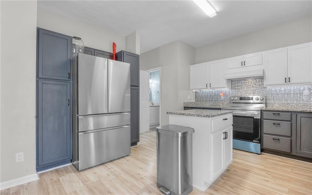 6329 Pelican Cres S, Suffolk, VA 23435 - kitchen featuring appliances with stainless steel finishes, under cabinet range hood, light wood-style flooring, light stone countertops, and decorative backsplash