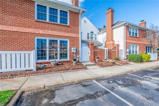 104 Camden Way Unit G, Yorktown, VA 23693 - view of front of property featuring uncovered parking, brick siding, a gate, and a chimney