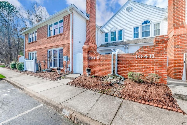 104 Camden Way Unit G, Yorktown, VA 23693 - traditional-style home featuring a chimney, brick siding, and uncovered parking