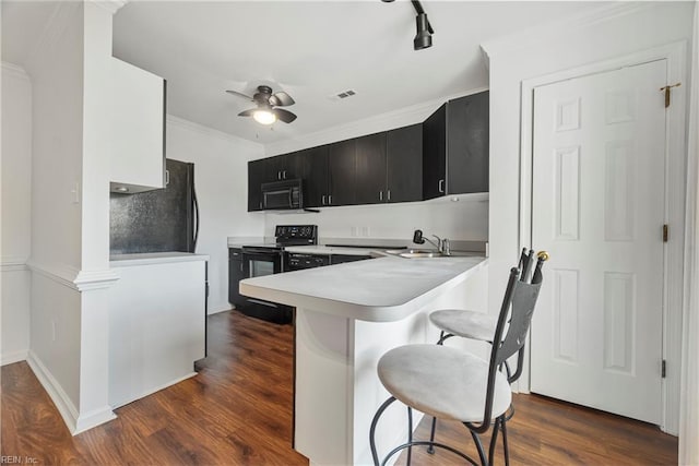 104 Camden Way Unit G, Yorktown, VA 23693 - kitchen with black appliances, dark cabinetry, a kitchen bar, light countertops, and a ceiling fan