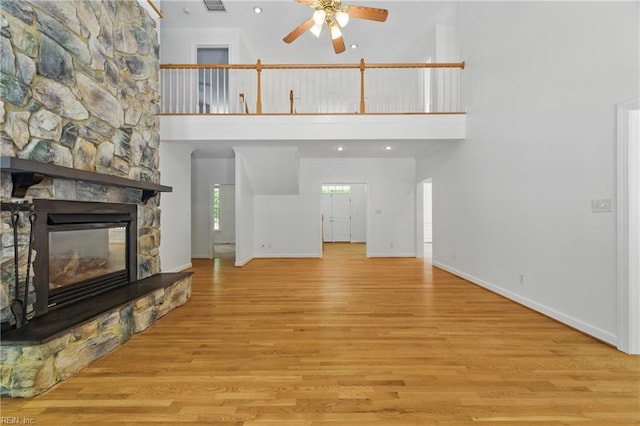 133 Mid Ocean, Williamsburg, VA 23188 - unfurnished living room with ceiling fan, wood finished floors, baseboards, a towering ceiling, and a stone fireplace