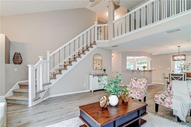 6100 Amberly Cir, Suffolk, VA 23435 - living area featuring stairway, wood finished floors, high vaulted ceiling, baseboards, and a chandelier