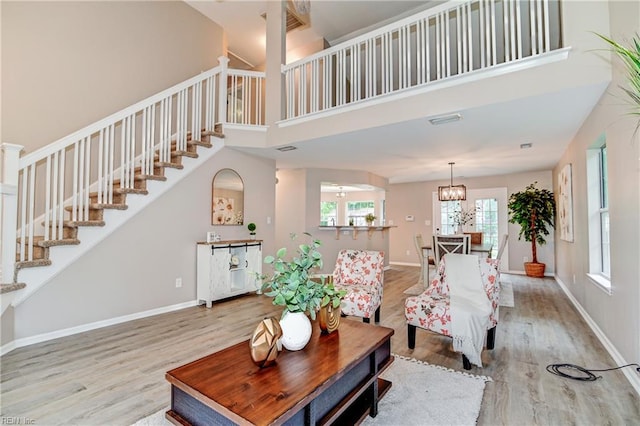 6100 Amberly Cir, Suffolk, VA 23435 - living room with wood finished floors, stairs, a towering ceiling, baseboards, and a chandelier