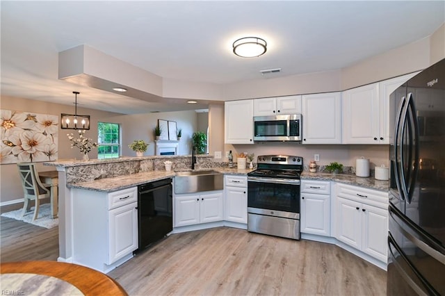 6100 Amberly Cir, Suffolk, VA 23435 - kitchen with black appliances, a sink, a peninsula, white cabinets, and light wood-style floors