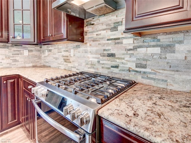 88 Alexandria Way, Carrollton, VA 23314 - kitchen with stainless steel range with gas stovetop, premium range hood, tasteful backsplash, and light stone counters