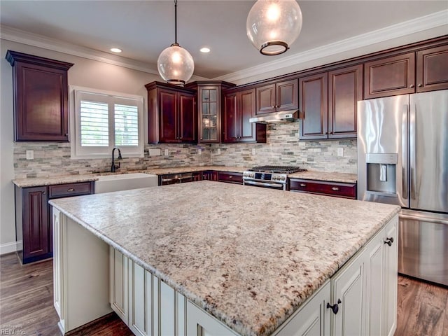 88 Alexandria Way, Carrollton, VA 23314 - kitchen with appliances with stainless steel finishes, a sink, a kitchen island, under cabinet range hood, and crown molding