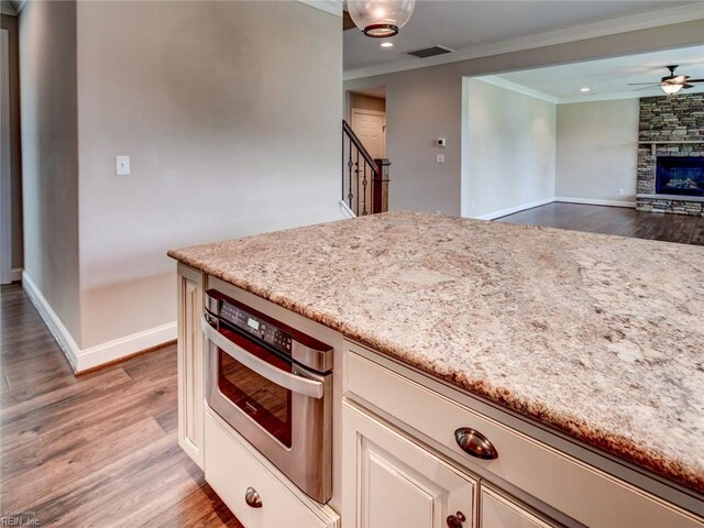 88 Alexandria Way, Carrollton, VA 23314 - kitchen featuring crown molding, oven, baseboards, light stone counters, and dark wood-style floors