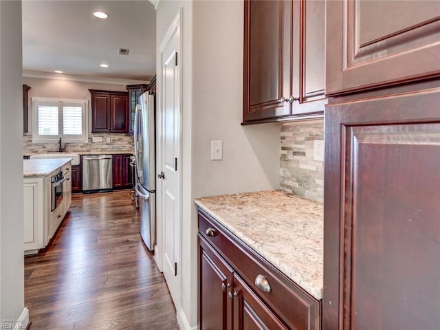 88 Alexandria Way, Carrollton, VA 23314 - kitchen with appliances with stainless steel finishes, ornamental molding, backsplash, dark wood-style floors, and light stone countertops