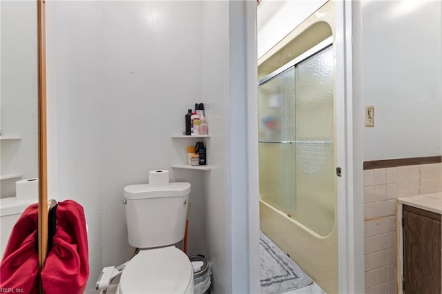 603 Page Dr, Hampton, VA 23669 - bathroom featuring vanity, toilet, tile walls, bathtub / shower combination, and wainscoting