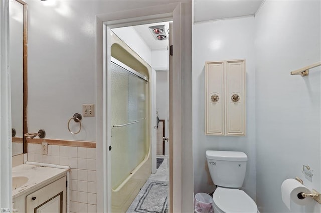 603 Page Dr, Hampton, VA 23669 - bathroom with toilet, vanity, tile walls, and combined bath / shower with glass door