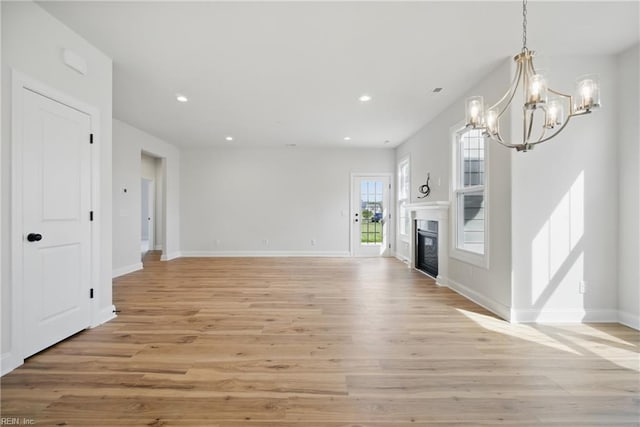 225 Ayrshire Loop, Smithfield, VA 23430 - unfurnished living room with a chandelier, recessed lighting, light wood-style floors, baseboards, and a glass covered fireplace