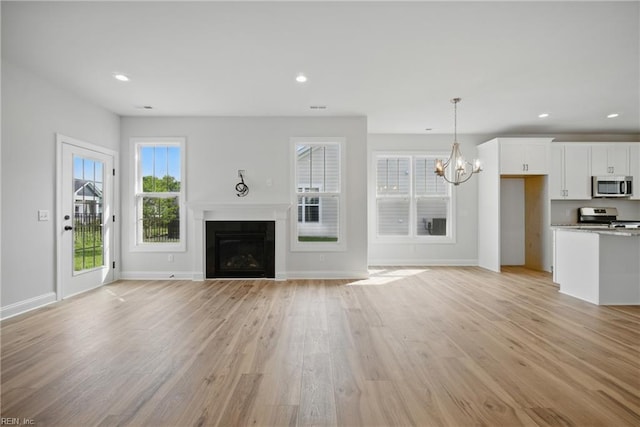 225 Ayrshire Loop, Smithfield, VA 23430 - unfurnished living room with a chandelier, a fireplace, light wood finished floors, baseboards, and recessed lighting