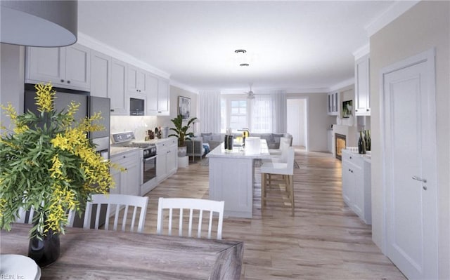 605 Jaden Way, Virginia Beach, VA 23454 - kitchen with range with gas stovetop, open floor plan, light wood finished floors, a kitchen bar, and white cabinets