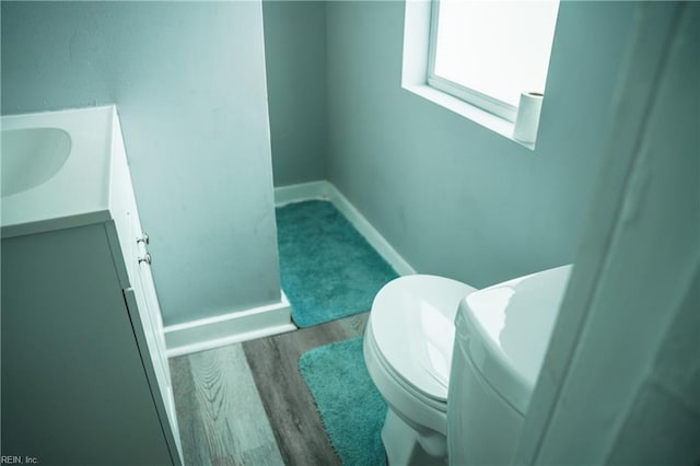 12 Benton Ave, Portsmouth, VA 23702 - half bathroom with vanity, toilet, wood finished floors, and baseboards