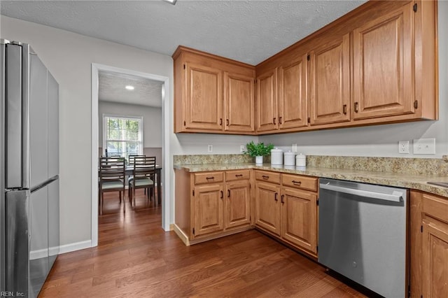 700 Canteberry Ln, Smithfield, VA 23430 - kitchen with appliances with stainless steel finishes, dark wood-style floors, light countertops, a textured ceiling, and brown cabinetry