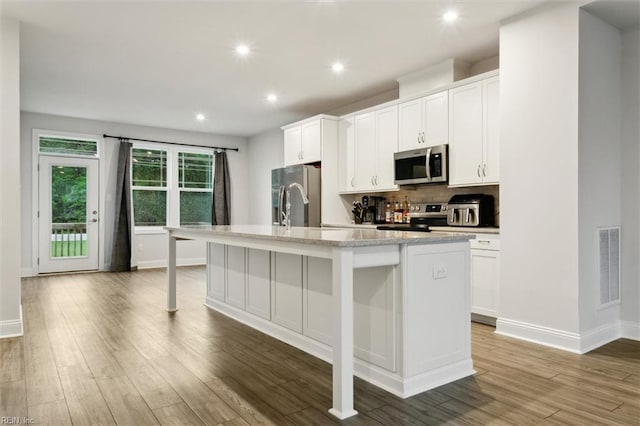 1544 Stanford Ln, Newport News, VA 23608 - kitchen featuring stainless steel appliances, an island with sink, baseboards, wood finished floors, and recessed lighting