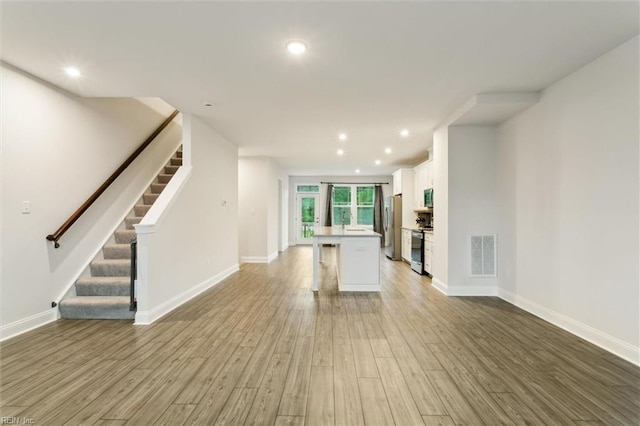 1544 Stanford Ln, Newport News, VA 23608 - unfurnished living room featuring light wood finished floors, stairway, recessed lighting, and baseboards