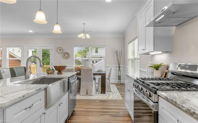 1608 Holland Ave, Norfolk, VA 23509 - kitchen with appliances with stainless steel finishes, wall chimney exhaust hood, light wood-style flooring, a sink, and ornamental molding
