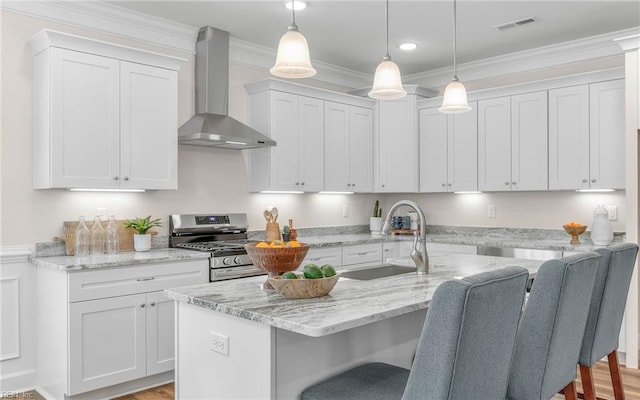 1608 Holland Ave, Norfolk, VA 23509 - kitchen featuring wall chimney exhaust hood, gas stove, a sink, a breakfast bar, and white cabinetry