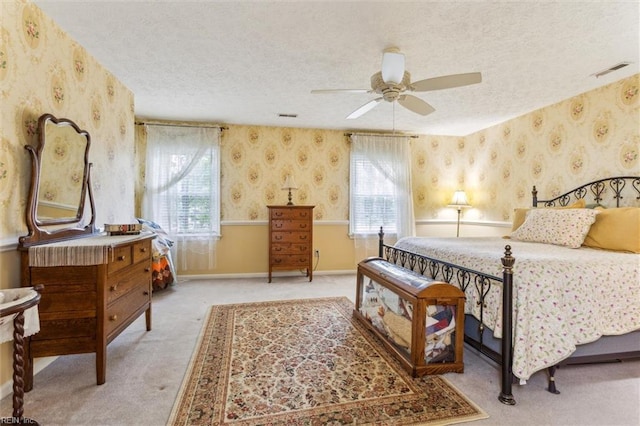 105 Stavenger Ct, Williamsburg, VA 23188 - bedroom featuring wallpapered walls, a textured ceiling, multiple windows, light colored carpet, and a ceiling fan
