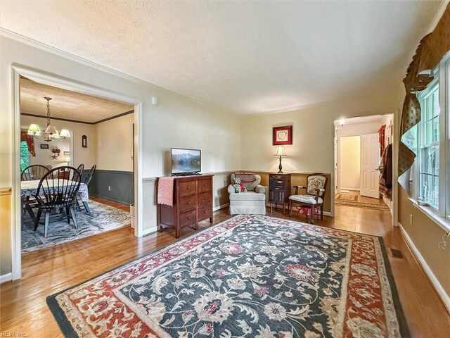 105 Stavenger Ct, Williamsburg, VA 23188 - living area with wood finished floors, a chandelier, ornamental molding, baseboards, and a textured ceiling