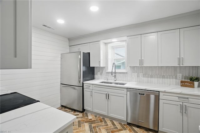 6223 Rolfe Ave, Norfolk, VA 23508 - kitchen with stainless steel appliances, a sink, ornamental molding, light stone counters, and wood walls