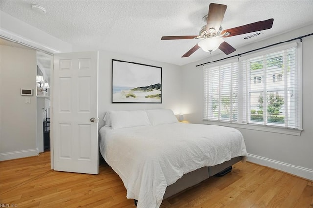 6223 Rolfe Ave, Norfolk, VA 23508 - bedroom featuring baseboards, multiple windows, a textured ceiling, and light wood finished floors