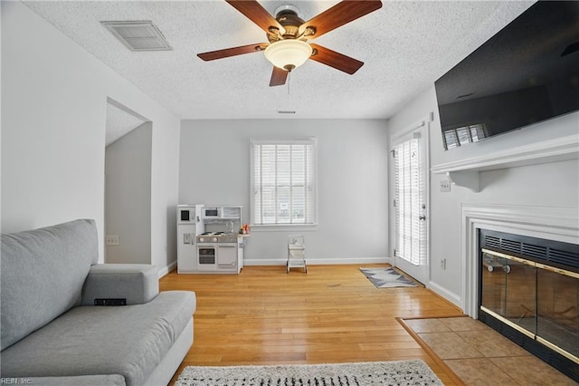 6223 Rolfe Ave, Norfolk, VA 23508 - living area with a textured ceiling, a fireplace with flush hearth, wood finished floors, ceiling fan, and baseboards