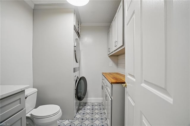 6223 Rolfe Ave, Norfolk, VA 23508 - bathroom featuring estacked washer and dryer, vanity, toilet, ornamental molding, and baseboards
