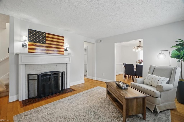 6223 Rolfe Ave, Norfolk, VA 23508 - living area with a textured ceiling, a chandelier, wood finished floors, and a brick fireplace