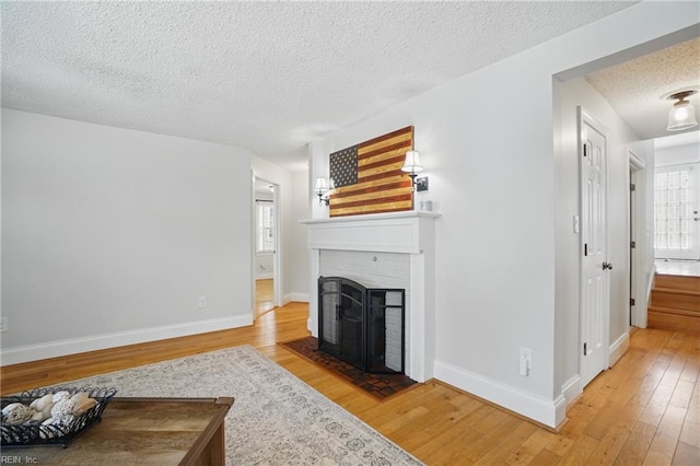 6223 Rolfe Ave, Norfolk, VA 23508 - living room with a textured ceiling, light wood-style flooring, a fireplace with flush hearth, and baseboards