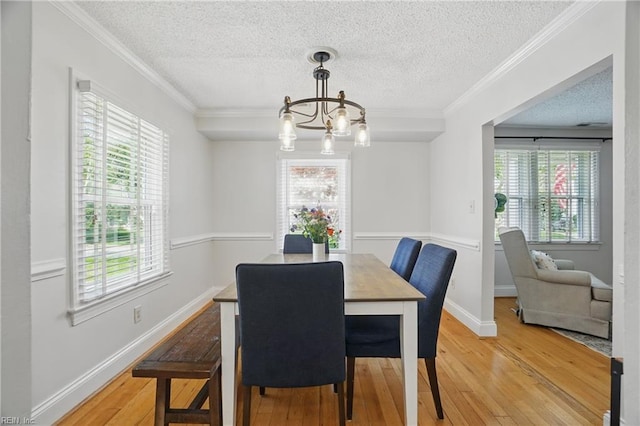 6223 Rolfe Ave, Norfolk, VA 23508 - dining space with a chandelier, a textured ceiling, light wood-style flooring, crown molding, and baseboards