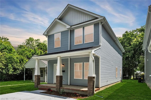 308 N Division St Unit A, Suffolk, VA 23434 - view of front of house with covered porch, a front yard, central air condition unit, and board and batten siding