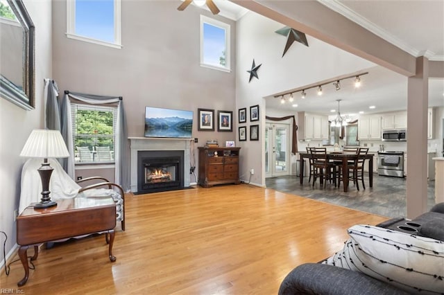 108 Silver Fox Trce, Yorktown, VA 23693 - living area with a fireplace with flush hearth, ornamental molding, a ceiling fan, light wood-style flooring, and a towering ceiling