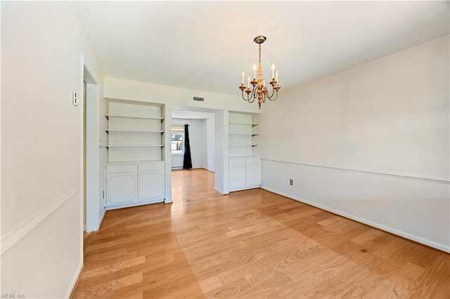 4456 Hudgins Dr, Virginia Beach, VA 23455 - unfurnished dining area featuring a chandelier, built in shelves, light wood-style flooring, and baseboards