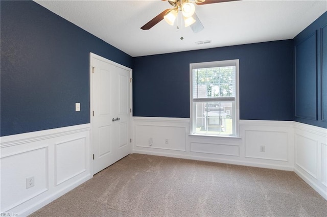 82 Beacon Rd, Portsmouth, VA 23702 - carpeted spare room with wainscoting, a ceiling fan, and a decorative wall