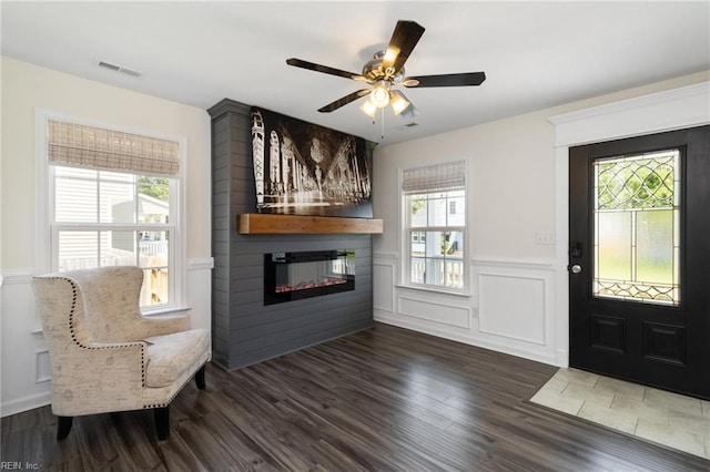 82 Beacon Rd, Portsmouth, VA 23702 - foyer entrance with a wainscoted wall, a glass covered fireplace, wood finished floors, ceiling fan, and a decorative wall