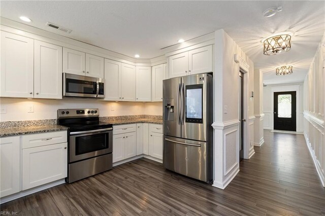 82 Beacon Rd, Portsmouth, VA 23702 - kitchen with stainless steel appliances, white cabinetry, wainscoting, recessed lighting, and a decorative wall