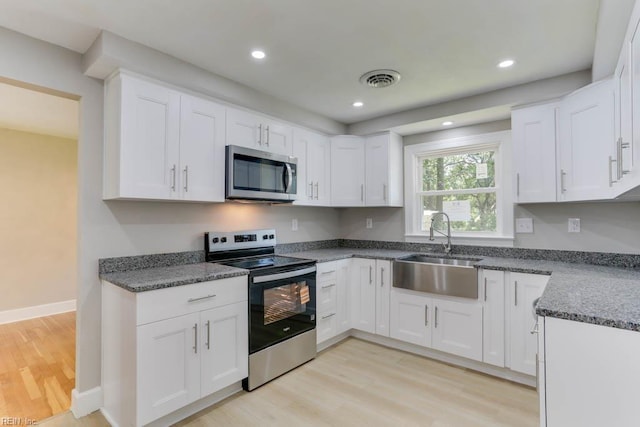 5833 Hedgerow Ln, Portsmouth, VA 23703 - kitchen with stainless steel appliances, a sink, light wood finished floors, white cabinetry, and recessed lighting