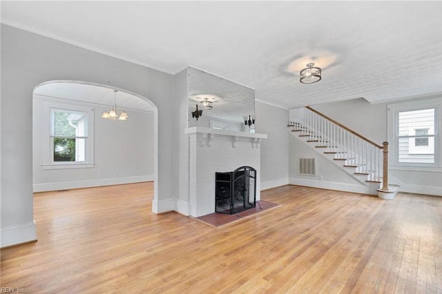309 Linden Ave, Suffolk, VA 23434 - unfurnished living room featuring healthy amount of natural light, wood finished floors, stairway, a fireplace, and ornamental molding